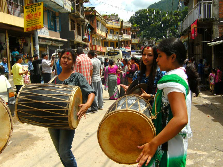 women dancing and playing Dhami